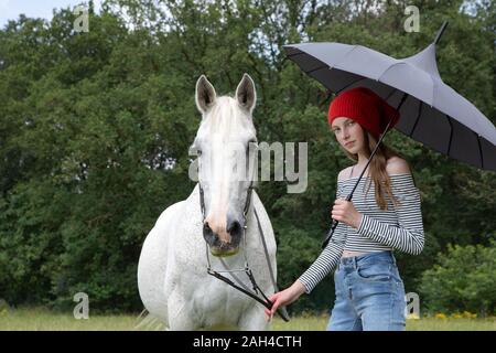 Portrait von Teenager stehen auf einer Wiese mit Pferd und Dach Stockfoto