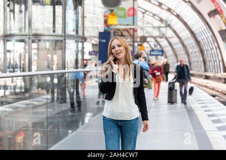 Frau am Telefon auf dem Bahnsteig, Berlin, Deutschland Stockfoto
