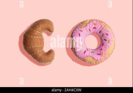 3D-Illustration, Plüsch fake Croissant und Donut Muster auf rosa Hintergrund Stockfoto