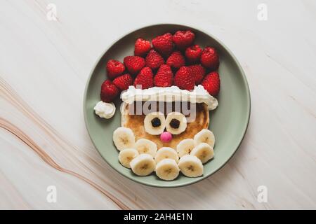 Weihnachten Santa Pfannkuchen mit Himbeeren und Banane für Kinder Frühstück, Ansicht von oben mit der Kopie. Stockfoto