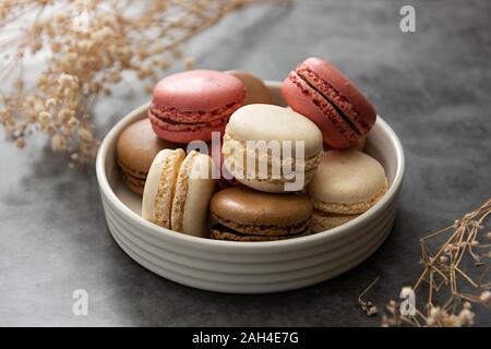 Französische macaron Kuchen in einem Teller hautnah. Creme, Braun, Rosa, Macarons mit kopieren. Stockfoto