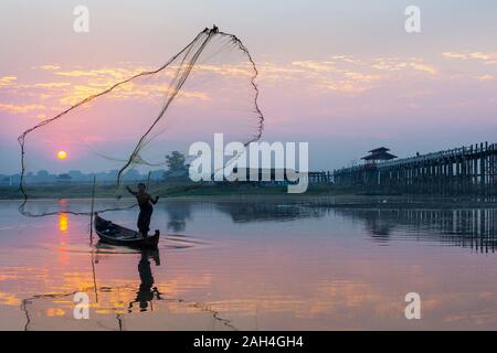 Fischer sein Netz Einstellung bei Sonnenaufgang in der Nähe der U-Bein Brücke, in Mandalay, Myanmar Stockfoto