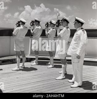 1950, historische, eine Gruppe von vier uniformierte Schiff Navigatoren auf dem Deck eines Dampfschiffes mit Sextanten, betreut durch den Kapitän. Sextanten sind maritime Messgeräte können Sie den Winkel zwischen dem Horizont und einem Himmelskörper wie Sonne, Mond oder Sterne zu bestimmen. Stockfoto