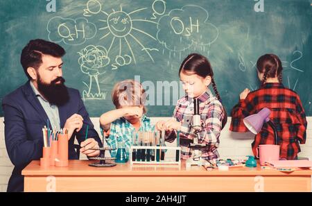 Wissenschaft ist immer die Lösung. Schule Chemie Experiment. Erklären der Chemie zu Kindern. Faszinierende Chemie Lektion. Man bärtige Lehrer und Schüler mit Reagenzgläsern im Klassenzimmer. Beobachten Sie die Reaktion. Stockfoto