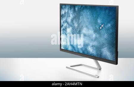 Computer Monitor mit einem Foto von dem Meer auf eine weiße Fläche Stockfoto