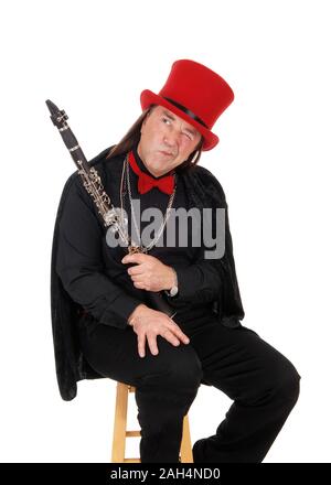 Ein mittleres Alter indigener seiner Klarinette Holding in einem schwarzen Outfit und Red Hat und Bow Tie weg suchen, auf weißem Hintergrund Stockfoto