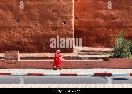 Eine Frau in Rot Spaziergänge auf einem Bürgersteig Stockfoto