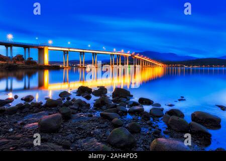 Tasman Brücke über den Derwent River bei Sonnenaufgang während der Blauen Stunde mit helle Beleuchtung leuchten in Blick auf Hobart Stadt am Wasser. Stockfoto