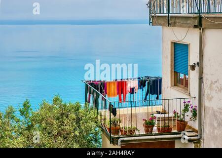 Bunte Wäsche trocknen auf der Wäscheleine im Freien auf einem Haus Balkon direkt am Mittelmeer an der Amalfi Küste, Italien. Stockfoto