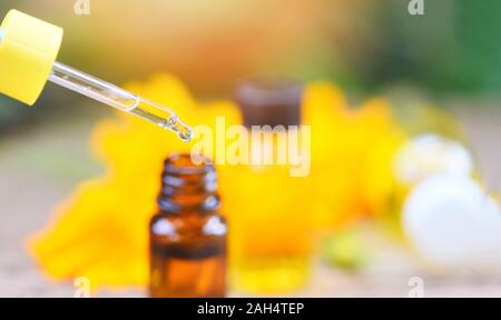 Aromatherapie pflanzliche Öl Flaschen aroma Dropper auf Glas mit Blume auf die Natur grün Hintergrund/Ätherische Öle natürliche für Gesicht und Körper Schönheit remedi Stockfoto