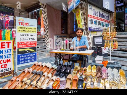 Straßenszene in Mahipalpur Bezirk, einem Vorort in der Nähe von Delhi Flughafen in New Delhi, die Hauptstadt Indiens: lokale Mann bei der Arbeit mit einem manuellen Nähmaschine Stockfoto