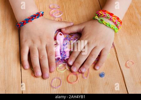 Kind Hände mit Gummibänder auf dem hölzernen Tisch Stockfoto