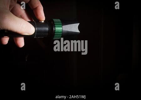 Männliche Hand hält eine Black Metal Taschenlampe Stockfoto