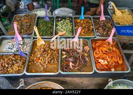 Eine Auswahl an verschiedenen Straße Nahrungsmittel für Verkauf an ein traditionelles Essen outlet als Carinderia innerhalb einer Seite Straße in der Innenstadt von Cebu City, Philippinen bekannt Stockfoto