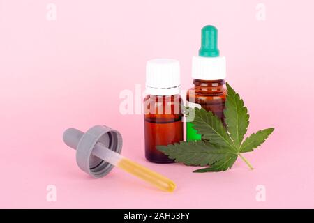 Marihuana Medikamente extrahieren. grünes Blatt und Cannabis Öl mit THC und CBD auf rosa Hintergrund. Stockfoto