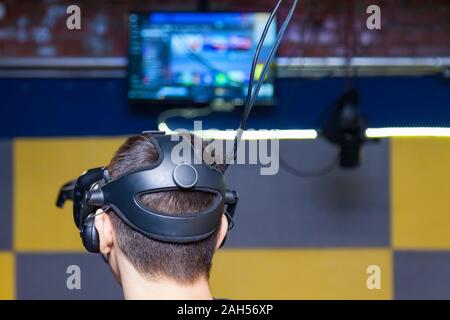 Der Kopf des Kerl ist eine Maske mit einem schwarzen Helm für Eintauchen in die virtuelle Realität verbunden mit einem 3D-Bild in die Spiele und Simulatoren mit erhöhter sensitivi Stockfoto