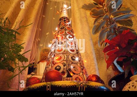Atemberaubender Mini-Weihnachtsbaum im Haus mit Hauspflanzen auf jeder Seite Stockfoto