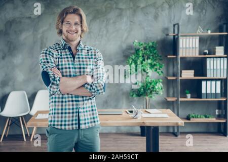 Porträt der freundliche Mann mit blonden Haaren verschränkte seine Hände tragen Brillen Brillen, karierten Plaid Shirt Hose im Innenraum Stockfoto