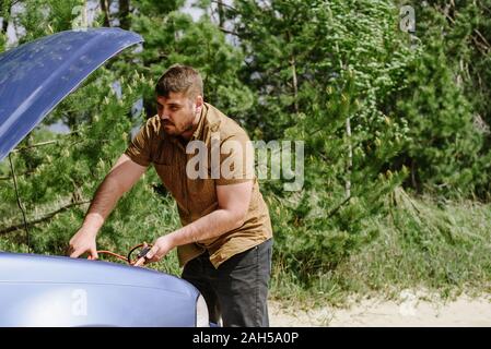 Der Fahrer versucht, eine kaputte Auto zu starten Stockfoto