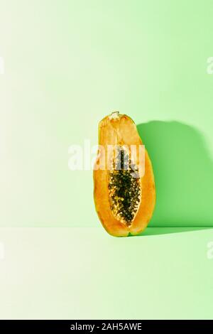 Die Hälfte der Reif und saftig Papaya steht auf einem blauen Hintergrund Stockfoto