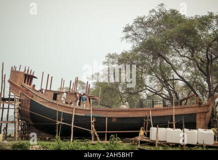 Banaras, Indien Oktober 2019 – AM Kakdwip-Strand wird EIN kleines modernes Fischerboot aus Holz auf einer Schiffsbaustelle gebaut. Stockfoto