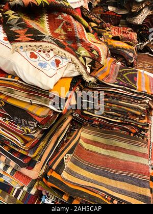 Türkische Teppiche und Kissen mit nationalen Mustern. Hintergrund aus Textil. Markt. Stockfoto