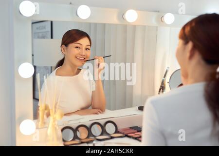 Schöne Frau mit Schönheit Gesicht Anwendung Lippenbalsam, Lipcare Stick auf. Lippen Hautpflege Kosmetik Konzept. Stockfoto