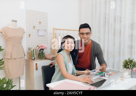 Foto fröhliche Frau und Mann Designer im Studio arbeitet Stockfoto
