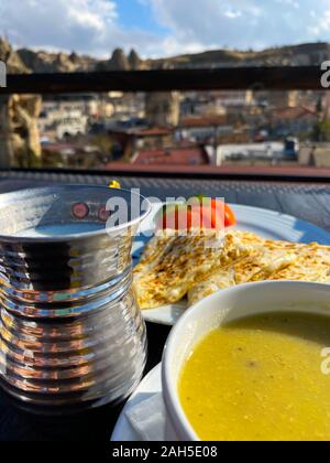 Suppe püriert, Pita, Tomaten stehen auf einem Tisch vor dem Hintergrund einer unscharfen Stadt Landschaft. Sonnigen Tag. Die Türkei. Abendessen. Tourismus. Stockfoto