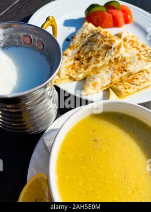 Suppe püriert, Pita, Tomaten stehen auf einem Tisch vor dem Hintergrund einer unscharfen Stadt Landschaft. Sonnigen Tag. Die Türkei. Abendessen. Tourismus. Stockfoto