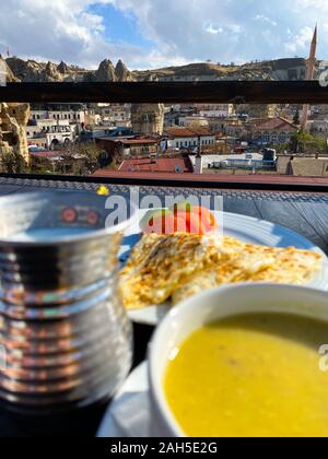 Suppe püriert, Pita, Tomaten stehen auf einem Tisch vor dem Hintergrund einer unscharfen Stadt Landschaft. Sonnigen Tag. Die Türkei. Abendessen. Tourismus. Stockfoto