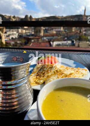 Suppe püriert, Pita, Tomaten stehen auf einem Tisch vor dem Hintergrund einer unscharfen Stadt Landschaft. Sonnigen Tag. Die Türkei. Abendessen. Tourismus. Stockfoto