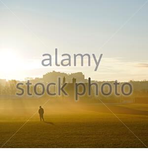 Edinburgh, Schottland, Großbritannien. 25. Dez 2019. Kalt, klar und hell mit geringer Masse Nebel am Weihnachtstag bei Sonnenaufgang in Inverleith Park, mit Blick auf das Edinburgh Castle. Menschen auf dem Weg in den Park. Quelle: Craig Brown/Alamy leben Nachrichten Stockfoto