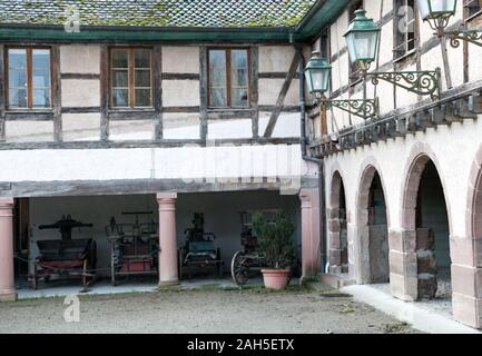 Ungersheim, Oberrhein/Frankreich - 13. Dezember, 2019: Blick auf das historische Fachwerkhaus elsässischen Land Haus und Hof mit alten Pferdekutschen carria Stockfoto