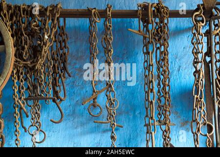 Aus der Nähe zu sehen. viele verrostete Ketten und Ringe an der Wand aufhängen, außerhalb von einem Schmied Fälschung Stockfoto