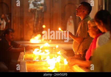 Colombo, Dez. 24. 21 Apr, 2019. Leute kommen Weihnachten Christmette in der St. Antonius Kirche in Colombo, Sri Lanka, Dez. 24, 2019. Zu den Teilnehmern gehörten viele Überlebende und Angehörige der Opfer des mehrere Bombenanschläge, Kirchen und Hotels im ganzen Land am 21 April, 2019 Hit. Credit: Tang Lu/Xinhua/Alamy leben Nachrichten Stockfoto
