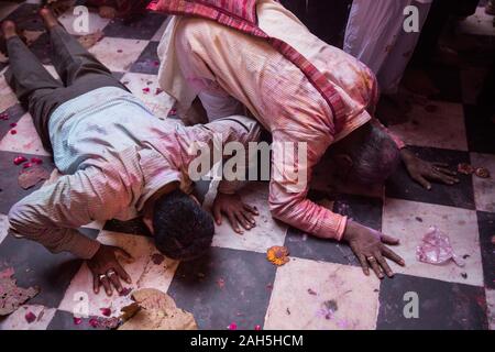 Männer liegen auf dem Boden der Bankey Bihari Temple. Vrindavan, Indien Stockfoto