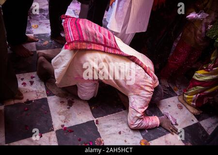 Mann kniend auf dem Boden der Bankey Bihari Temple. Vrindavan, Indien Stockfoto