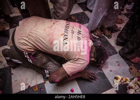 Mann kniend auf dem Boden der Bankey Bihari Temple. Vrindavan, Indien Stockfoto