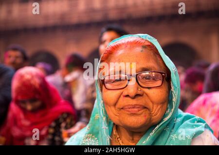 Frau lächelnd während Holi Feiern im Inneren Bankey Bihari Temple. Vrindavan, Indien Stockfoto