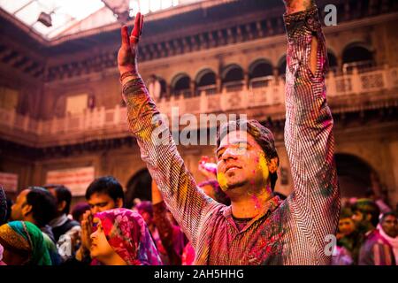 Mann hob seine Arme in Hingabe während Holi Feiern im Inneren Bankey Bihari Temple. Vrindavan, Indien Stockfoto