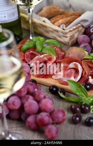 Antipasti. Wein Set snack getrockneten Schinken jamon mit Trauben und Oliven Stockfoto