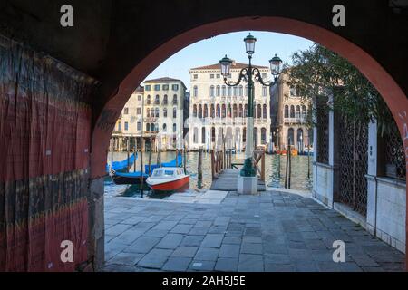 Blick durch den Bogen eines sotoportego oder überdachten Gang der historischen Plazzos am Grand Canal in San Marco, Venedig, Venetien, Italien bei Sonnenuntergang Stockfoto