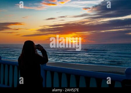 Silhouette einer Frau ist das Fotografieren eines Atlantischen Ozean Sonnenuntergang. Bei Vieira de Leiria. Ein portugiesisches Dorf und auch eine Gemeinde im Ma Stockfoto