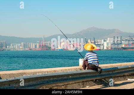 Fisher Mann mit Angelrute von hinten in der Nähe der Hafen in HongKong Stockfoto