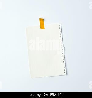 Weiß zerknittertes Blatt Papier aus einer Spirale notebook zerrissen und mit gelbem Isolierband auf weißem Hintergrund geklebt, Platz für Text. Design Space Stockfoto