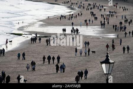 Wanderer am Weihnachtstag auf Tynemouth Beach an der nördlichen Ostküste. Stockfoto