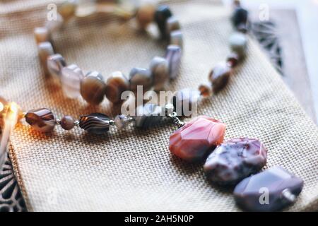 Reflexionen und Wellen. Schmuck Zusammensetzung auf die inneren Hintergrund mit Bokeh. Chainlet mit Natursteinen für Geschenk, Heiraten, Neues Jahr oder Geburtstag. B Stockfoto