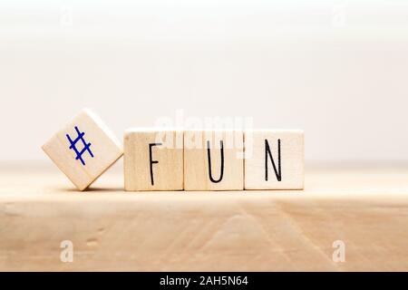 Holzwürfel mit hashtag und das Wort Spaß in verschiedenen Farben, social media Konzept Hintergrund Stockfoto