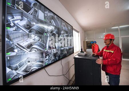 Changxing, der chinesischen Provinz Zhejiang. 25 Dez, 2019. Ein Arbeiter überwacht die elektrische Konstruktion erz Förderanlage an Dening Bergbau, Heping Stadt Changxing County in der ostchinesischen Provinz Zhejiang, Dez. 25, 2019. Changxing Grafschaft hat in den letzten Jahren wurde die Förderung der Nutzung von Elektrizität Abgas- und Lärmemissionen zu reduzieren. Credit: Xu Yu/Xinhua/Alamy leben Nachrichten Stockfoto